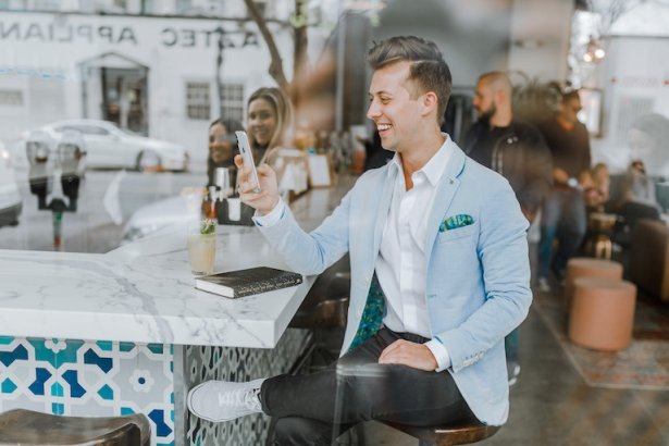 Man som använder en mobil enhet i en restaurang